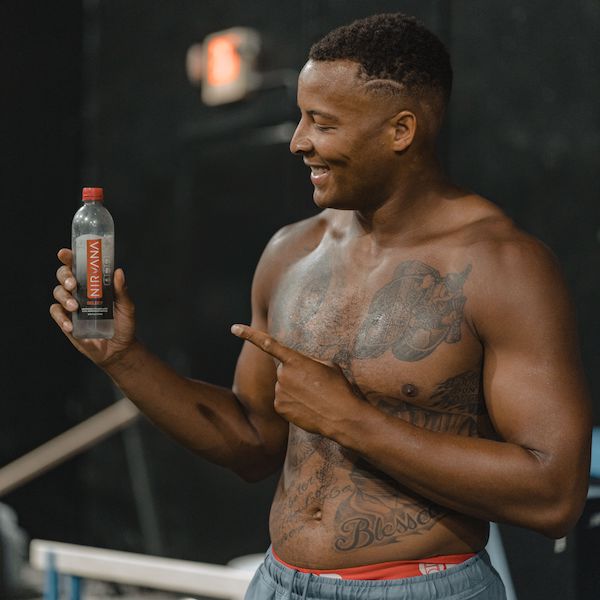 NFL Tight End Pharaoh Brown holding a bottle of Nirvana Select.